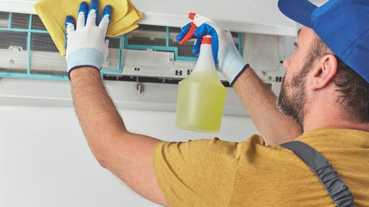 Air conditioning unit being serviced and maintained